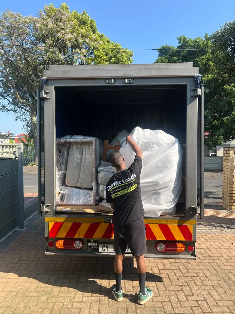 Terrific Loads team member loading wrapped furniture into a delivery truck